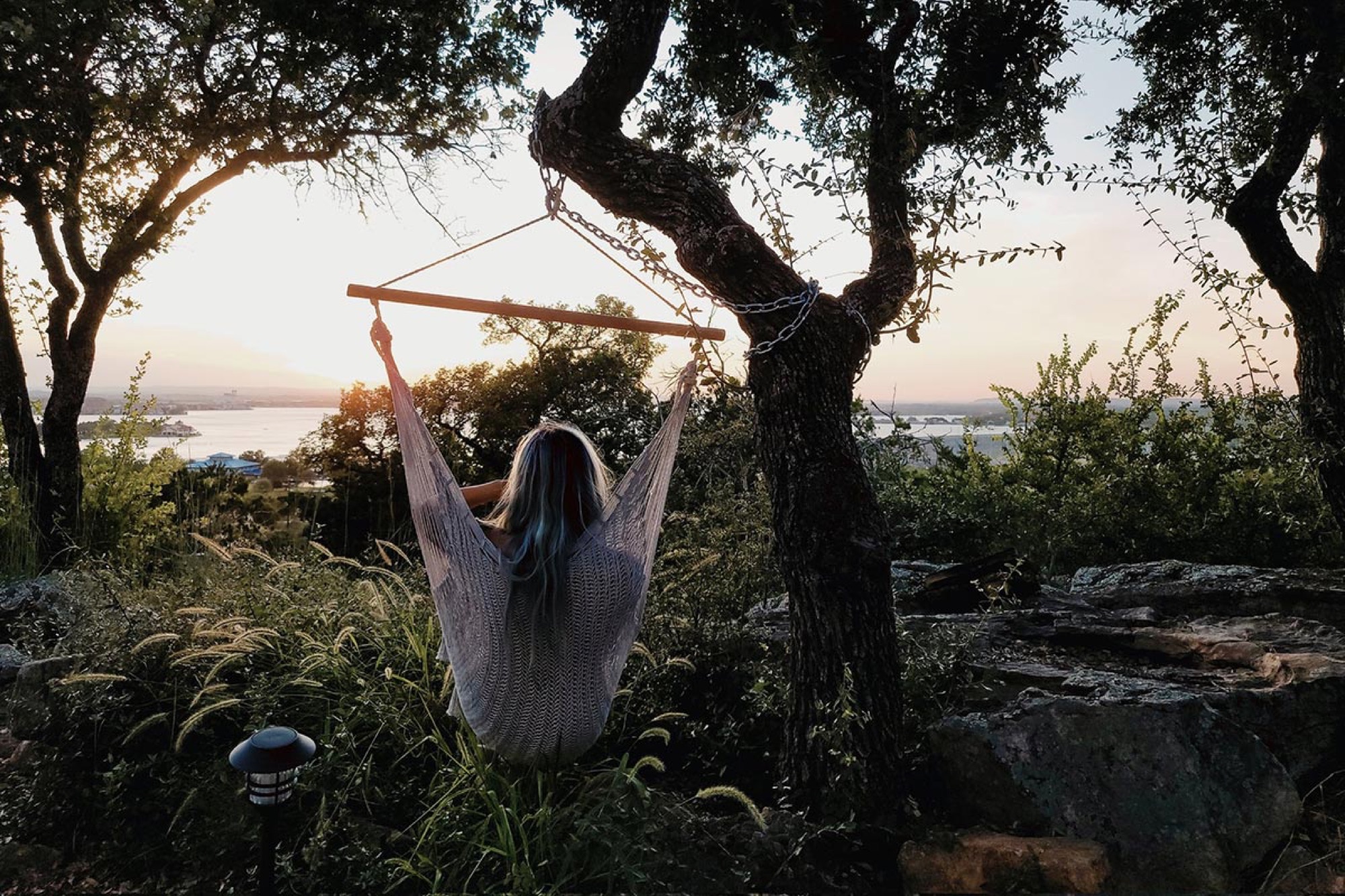 A guest on a swing at sunset over the Hill Country